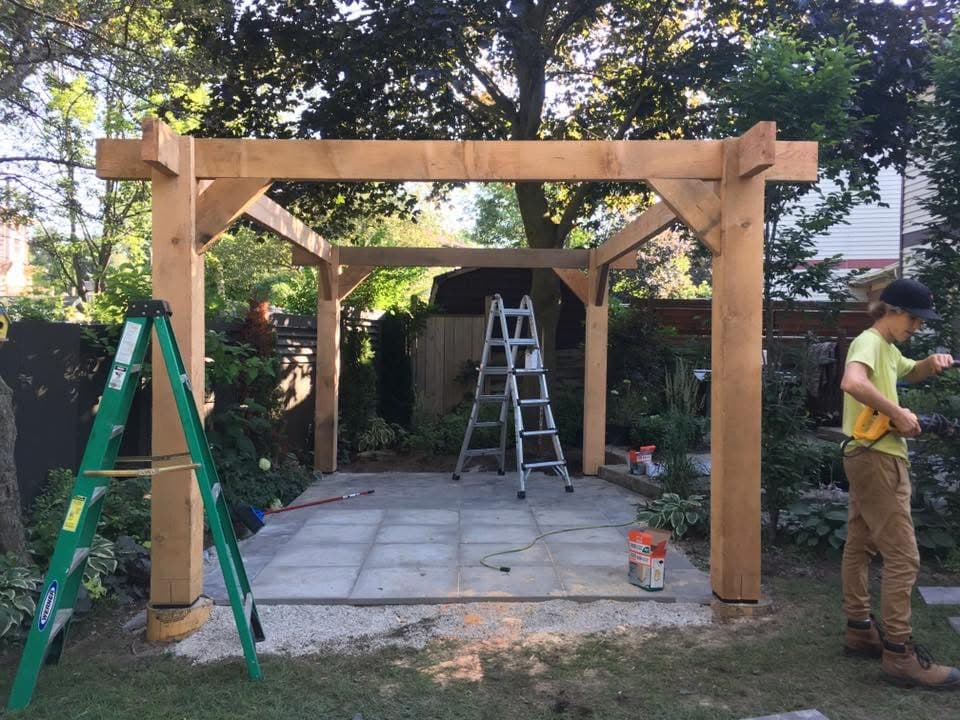 Pergola structure under construction in residential backyard